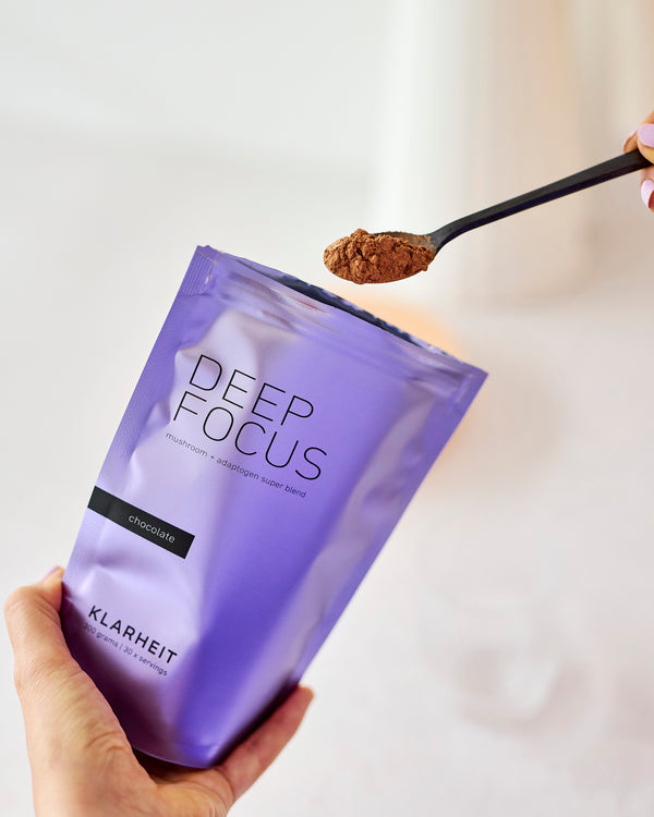 Eine Hand hält eine Packung DEEP FOCUS, darüber ein Löffel mit Pulver